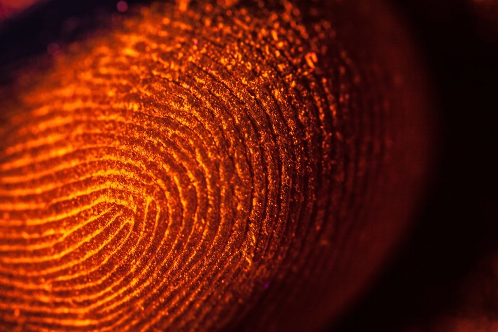 shutterstock_208573624-red-orange-fingerprints-on-black-unfocused